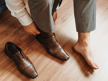 Elegant man putting on handcrafted luxury leather shoes, showcasing timeless craftsmanship