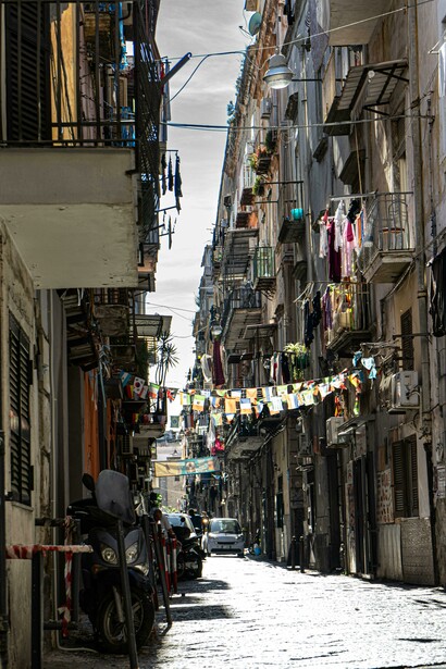In the heart of Naples, lanterns and flags line the narrow streets of the old town, Italy