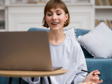 A woman engaged in e-learning at home, participating in a Zoom lecture that blends technology and education