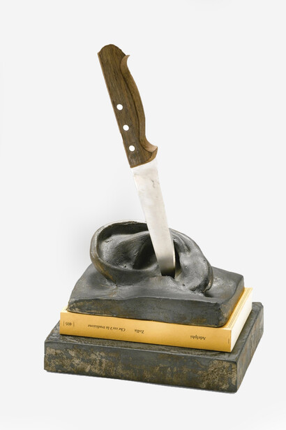 Che cos'è la tradizione, 1997 wood, metal, lead cast of ear, paper, iron 34 x 20 x 14 cms. Claudio Parmiggiani’s Che cos'è la tradizione? Literally pierces the silence of history—an ear, a knife, a book—symbolizing how tradition can wound, distort, or define how we listen, learn, and inherit meaning across generations. Image courtesy of the Artist/Estorick Collection of Modern Italian Art