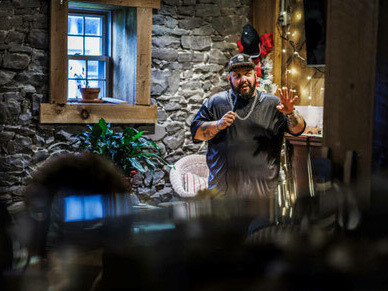 A Latino comedian performs a stand-up routine at a private country club