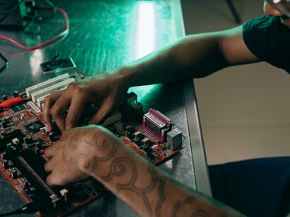 Primo piano sulle mani di una persona che lavora su una scheda madre