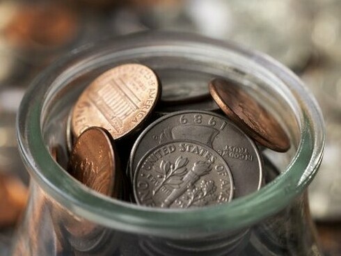 A brimming jar next to many coins, reflecting how large numbers tell the real story