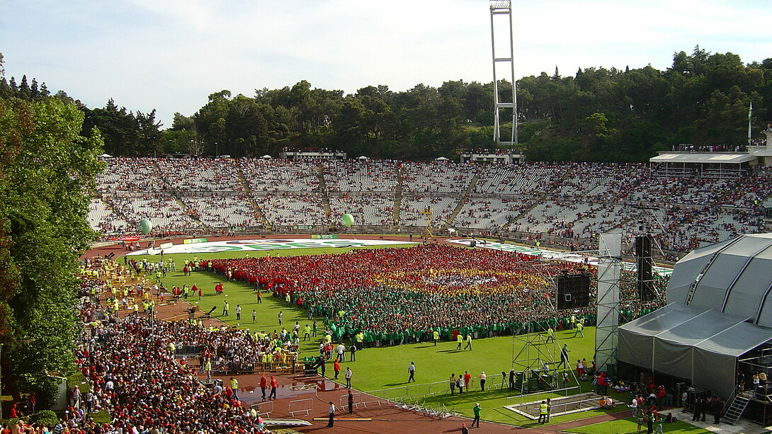 Estádio Nacional do Jamor durante o evento "A mais bela bandeira do mundo" - promoção da participação portuguesa no Mundial de Futebol 2006. No que diz respeito à Liga Portuguesa, uma alteração importante seria a mudança de horários dos jogos. Atualmente, muitos jogos ocorrem à noite, dificultando a ida das famílias aos estádios. Realizar os jogos ao fim de semana, durante a tarde, tornaria os estádios mais acessíveis para um público mais amplo, promovendo um ambiente familiar e inclusivo. Além disso, ao realizar os jogos nesse horário, as cidades vizinhas aos estádios poderiam beneficiar do aumento do turismo e da movimentação social, promovendo o futebol como uma atividade divertida para todas as idades