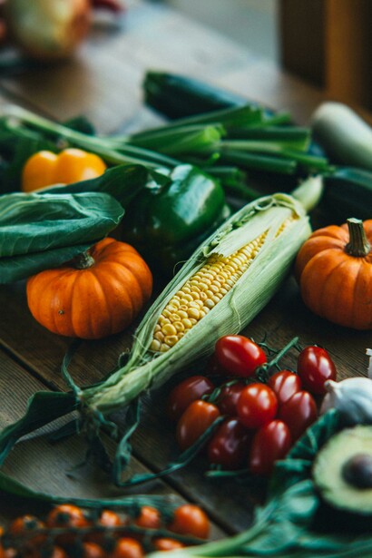 A selection of fresh, colorful vegetables arranged on a rustic wooden table, reflecting a healthy Paleo lifestyle