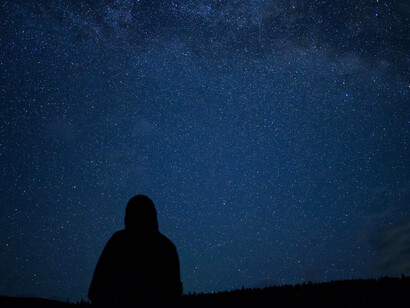 A person gazing at the stars, symbolizing the quiet journey into the unknown