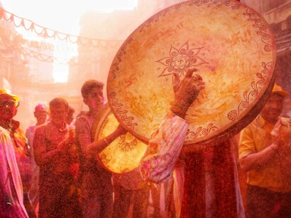 Kolkata, West Bengal, India — People celebrate Holi in a vibrant parade, covered in clouds of colorful powder