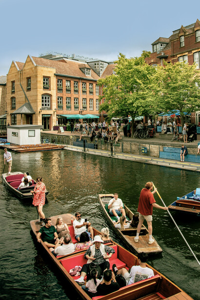 Tourists enjoying a boat ride along the River Cam in Cambridge, UK