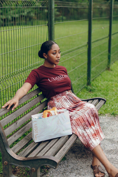 A young woman sitting alone on a park bench