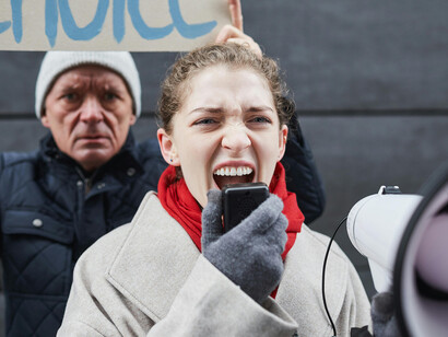 A woman holding a megaphone leads a freedom of expression protest, embodying the power of public discourse