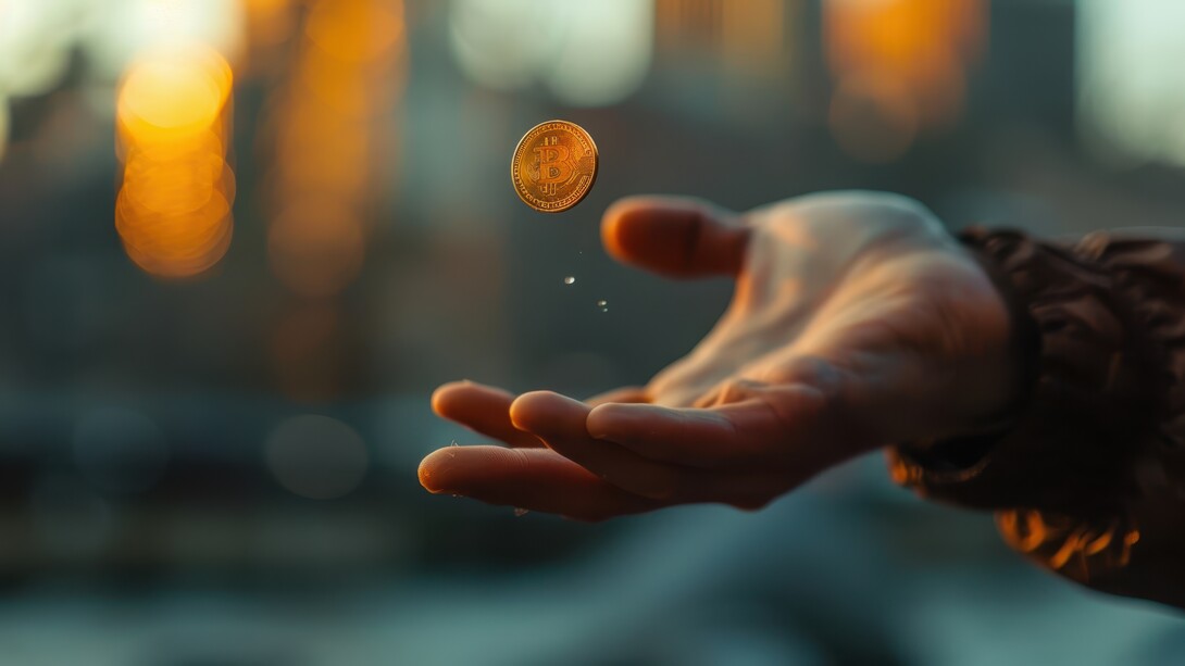 A person waiting to catch a flipping coin, capturing the illusion of fairness behind everyday decision-making