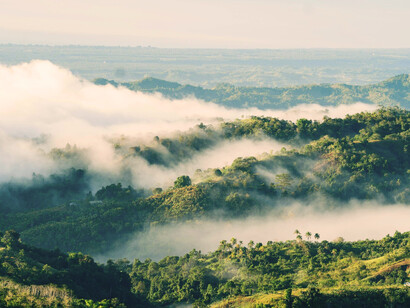 A scene of fog settling over distant peaks, reflecting the peaceful side of mountain regions in Mindanao, Philippines