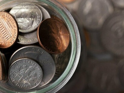 A jar of collected coins beside scattered ones, showing how randomness changes when tested enough