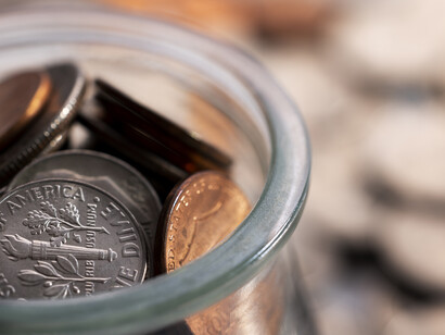 A jar full of coins beside scattered ones, showing how many flips reveal small patterns
