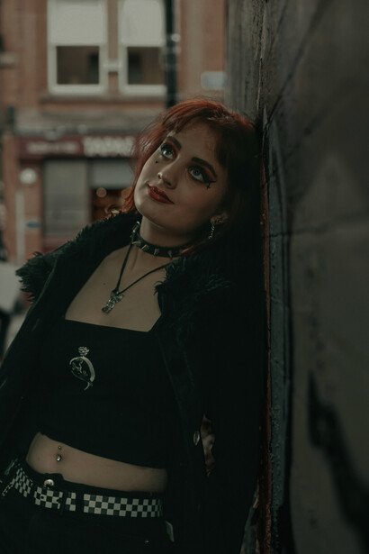 Tattooed woman with dyed hair dressed in a crop top, symbolizing rebellious youth style