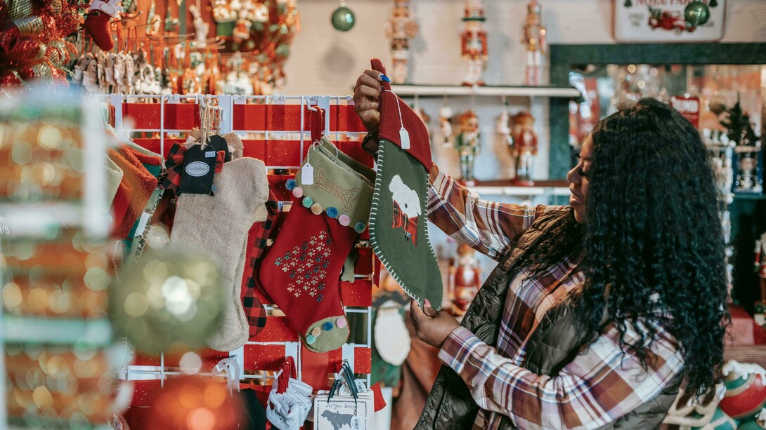 A smiling Black woman choosing Christmas decorations in a store