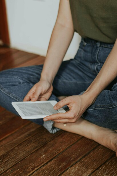 Mulher lê livro em leitor de e-books. Mas, ao mesmo tempo, enfrentamos o impacto da “cultura das distrações”. Redes sociais, vídeos curtos e notificações constantes competem pela nossa atenção. Muitos de nós lemos mais do que nunca — mas não necessariamente livros ou textos profundos