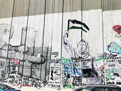 Words and images of protest on the separation wall, reflecting the connection between local acts of rebellion and worldwide support