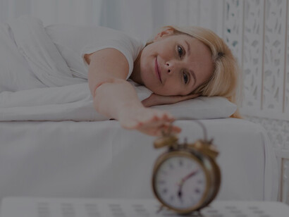 A happy woman sleeping peacefully highlights the connection between improved sleep quality, reduced anxiety, and better mental health