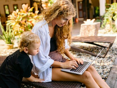 A mother managing both work and childcare, showing why empowering women strengthens entire communities