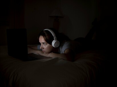 A face illuminated by data, caught in the pull of the digital attention machine