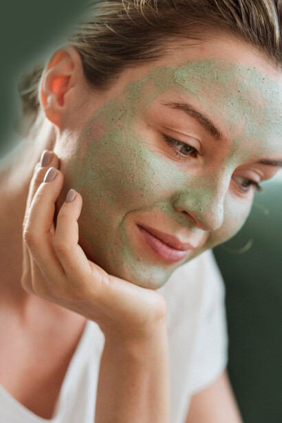 A woman applies an organic facial mask as part of her skincare routine for acne treatment and healthy skin