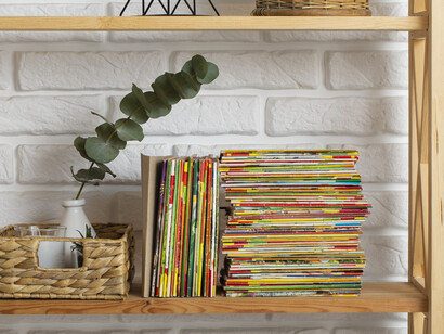 Popular manga volumes stacked neatly, mirroring the mainstream embrace of mature themes and complex heroes