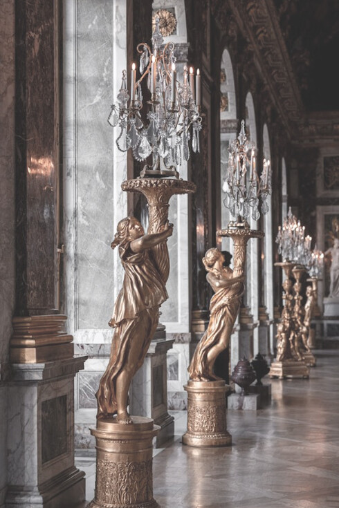 Visitors admire the grandeur of the Galerie des Glaces in the historic Château de Versailles, France