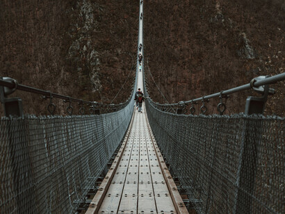 La transition subtile d'un bout à l'autre du pont représente les liens invisibles qui unissent les différentes strates de la réalité, du physique au métaphysique, sous l'effet d'une force continue et dynamique