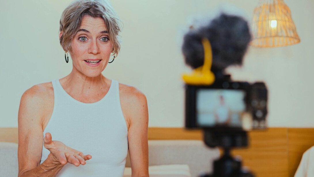 A video camera recording an elderly woman as she vlogs