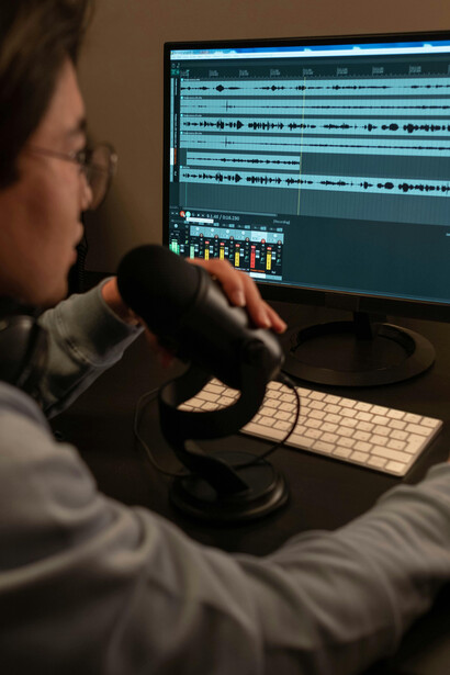 A person pointing at a screen, using voice commands in an interactive sound installation