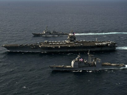 American vessels cut through open waters, representing both deterrence and deepening geopolitical strain