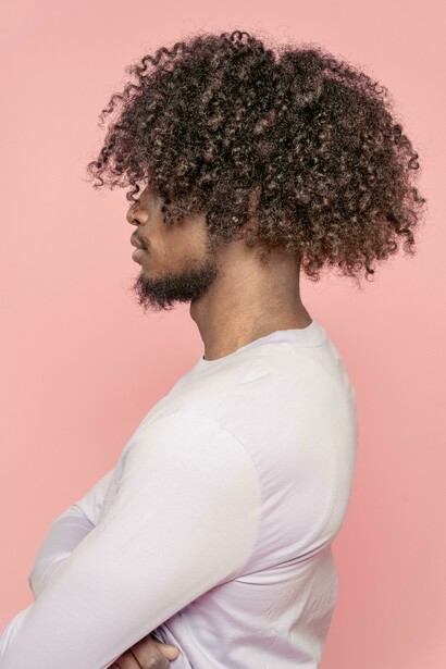 Serious Black man with an Afro and long natural curls falling over his eyes