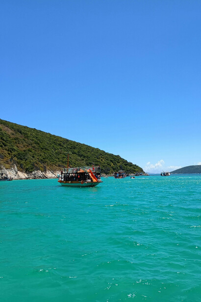 A scenic view of a boat filled with people exploring a beautiful coastal area