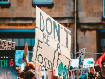 A group of protesters holding signs outside a building, demonstrating against the climate crisis and global warming
