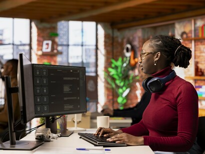 A woman working on coding, highlighting the need for more diversity and inclusion in the male-dominated tech industry