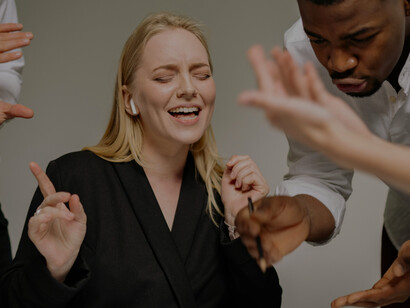 Business people have a discussion in a meeting while a woman wearing headphones is not listening