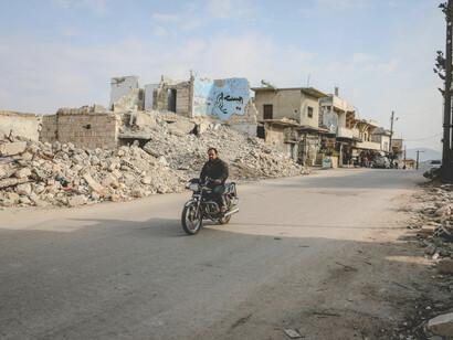 Idlib, Idlib Governorate, Syria. An unidentified biker passes through a neighborhood of demolished homes after years of conflict