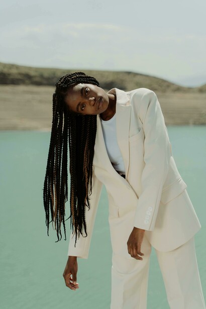 Elegant woman in a white suit with box braids