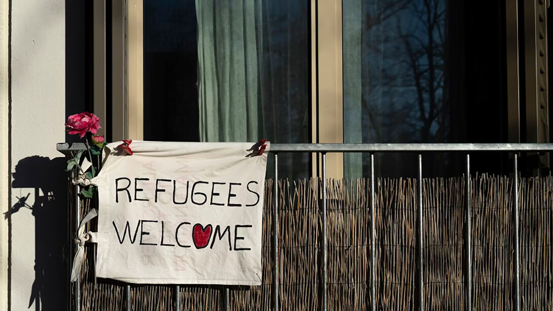 A sign reading "Refugees Welcome" displayed on a building
