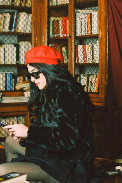 Mulher lê livro em biblioteca. E aí veio a televisão. Pela primeira vez, a leitura começou a competir com um meio de comunicação mais visual e dinâmico. Mesmo assim, o hábito de ler continuou forte — embora já começasse a mostrar sinais de mudanças