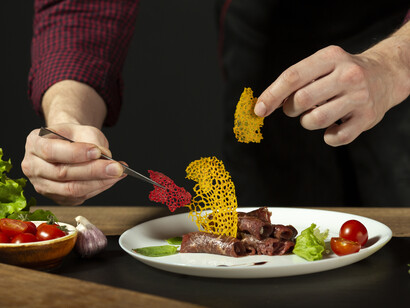 A person carefully plating a meal, symbolizing the impact of policy on food production and pricing