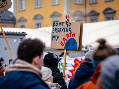 Demonstrators gathered with signs outside a building, raising awareness about climate change and global warming
