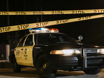 A police vehicle parked at the edge of the crime scene