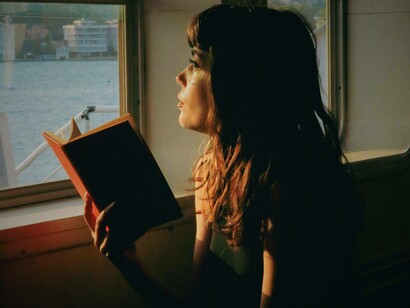 Donna in treno con un libro aperto in mano: "Quando il treno partì notò che tutti avevano un libro in mano e si preoccupò di trovarne una copia per sé, si trattava di "Due" di Irène Némirovsky"