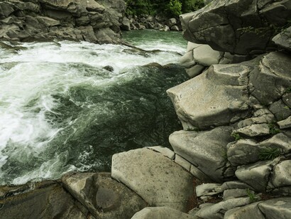 A river moving over stones—softness reshaping the hard, just as patience and integrity can reshape global politics