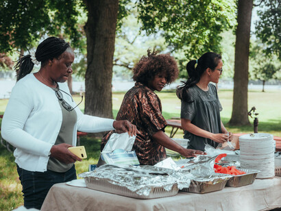 A group of people enjoying a social gathering in a park, expressing the spirit of community, togetherness, human connection, and collective unity