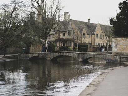 Bourton-on-the-Water, often called the "Venice of the Cotswolds," is a picturesque village in Cheltenham, UK, renowned for its tranquil river, charming stone bridges, and idyllic, lush surroundings