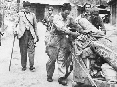 Palestinians being displaced after the fall of Haifa, accompanied by armed Haganah personnel, April 1948