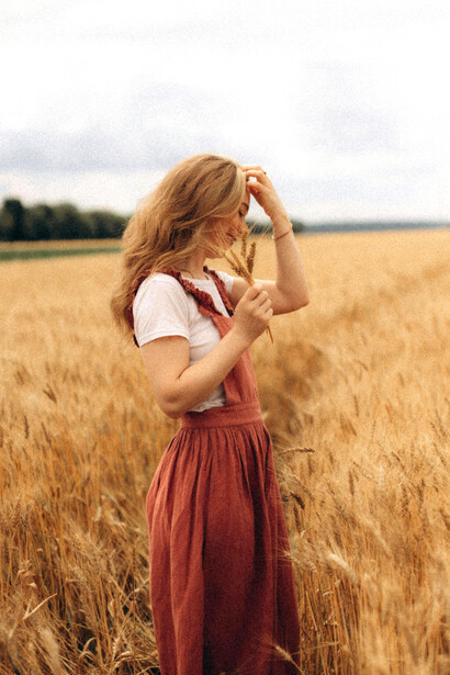 A woman standing in a golden wheat field, embodying change, transformation, and the quiet strength of personal growth